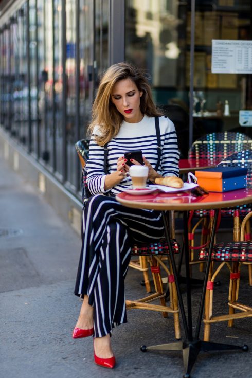 PARIS, FRANCE - OCTOBER 01: German model and fashion blogger Alexandra Lapp (@alexandralapp_) sitting in a French Cafe drinking coffee and eating Croissant wearing striped jumper from Steffen Schraut, striped pants from Emilio Pucci, suspenders H&M, Gianvito Rossi shoes and Mark Cross bag on October 1, 2016 in Paris, France. (Photo by Christian Vierig/Getty Images) *** Local Caption *** Alexandra Lapp