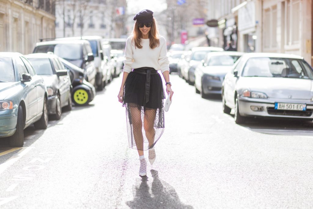 PARIS; FRANCE; Blogger and Model Alexandra Lapp rock dots by wearing knit Oui Black Lace Layer Skirt from Storets with layers of differently patterned sheer fabrics, a classic skater style silhouette with lace and dotted patterns cascading down below the leg, Leather waist belt - Set Fashion, Socks - vintage, Pumps - white snake pumps from Christan Louboutin, Sunglasses - Celine Audrey, Clutch - Chanel on March 3, 2017 in Paris, France.