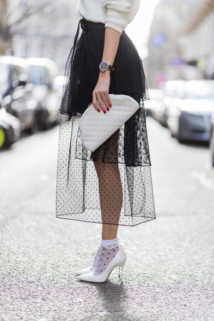 PARIS; FRANCE; Blogger and Model Alexandra Lapp rock dots by wearing knit Oui Black Lace Layer Skirt from Storets with layers of differently patterned sheer fabrics, a classic skater style silhouette with lace and dotted patterns cascading down below the leg, Leather waist belt - Set Fashion, Socks - vintage, Pumps - white snake pumps from Christan Louboutin, Sunglasses - Celine Audrey, Clutch - Chanel on March 3, 2017 in Paris, France.