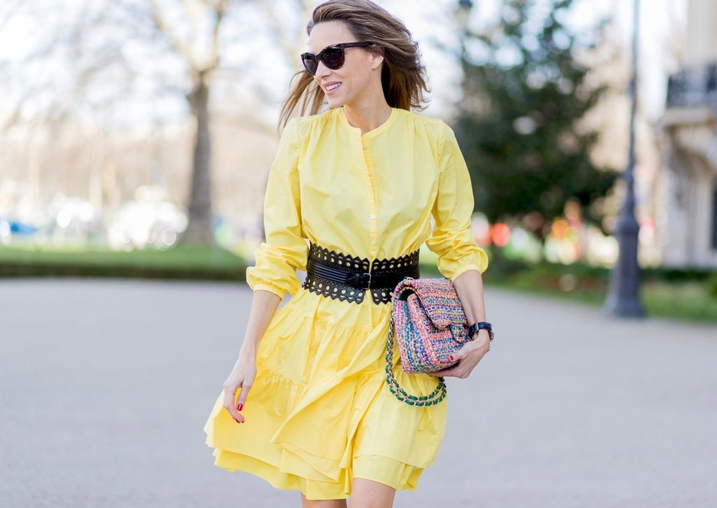 PARIS, FRANCE - MARCH 03: Alexandra Lapp wearing a yellow sunshine dress by Marc Cain, loose-fitting dress with flounce-like tiers, narrow, single-buttoned,(waist belt) Azzedine Alaia, Chiara Butterfly style sandals from Sophia Webster ( printed Butterfly Wing sandal, finished with a silver mirror front strap), cat eye sunglasses with pearls from Chanel, Chanel bag on March 3, 2017 in Paris, France. (Photo by Christian Vierig/Getty Images)