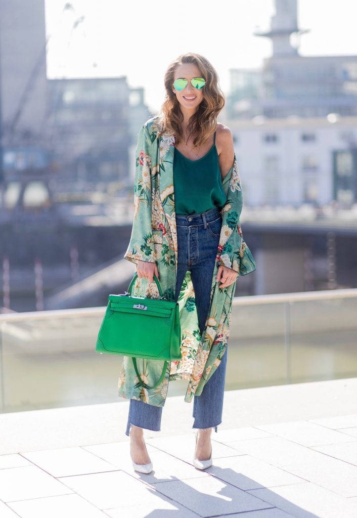 Model and fashion blogger Alexandra Lapp has a Kimono Love, wearing a green flower printed kimono from Zara, a green tank top in silk, blue jeans from Vetements in cooperation with LeviÂ´s with cut-out raw hems, white snake pumps from Christian Louboutin, Ray Ban Aviator sunglasses in green and a Hermes Kelly Ghillies 35 bag in green bamboo on March 30, 2017 in Duesseldorf, Germany.