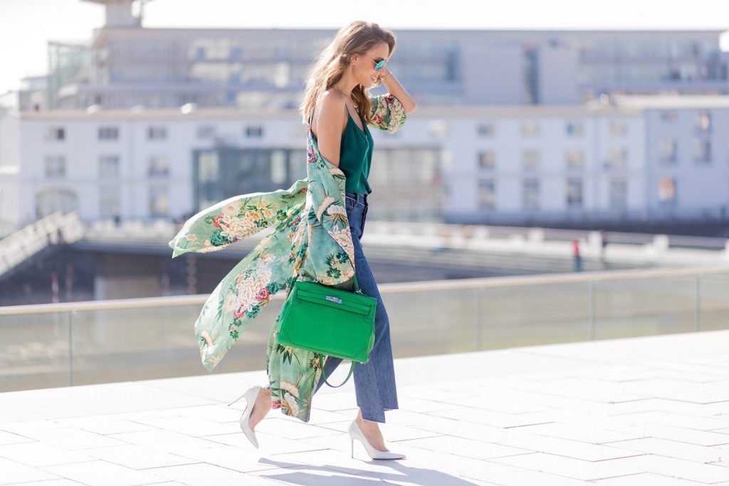 Model and fashion blogger Alexandra Lapp has a Kimono Love, wearing a green flower printed kimono from Zara, a green tank top in silk, blue jeans from Vetements in cooperation with LeviÂ´s with cut-out raw hems, white snake pumps from Christian Louboutin, Ray Ban Aviator sunglasses in green and a Hermes Kelly Ghillies 35 bag in green bamboo on March 30, 2017 in Duesseldorf, Germany.