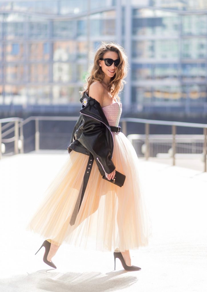 Model and fashion blogger Alexandra Lapp wearing a Carrie Bradshaw style, a multicolored sleeveless brocade tulle dress from Natasha Zinko, a black biker leather jacket with sewed on flowers with pearl applications from Natasha Zinko, black suede So Kate pums from Christian Louboutin, and black sunglasses from Celine on March 30, 2017 in Duesseldorf, Germany.