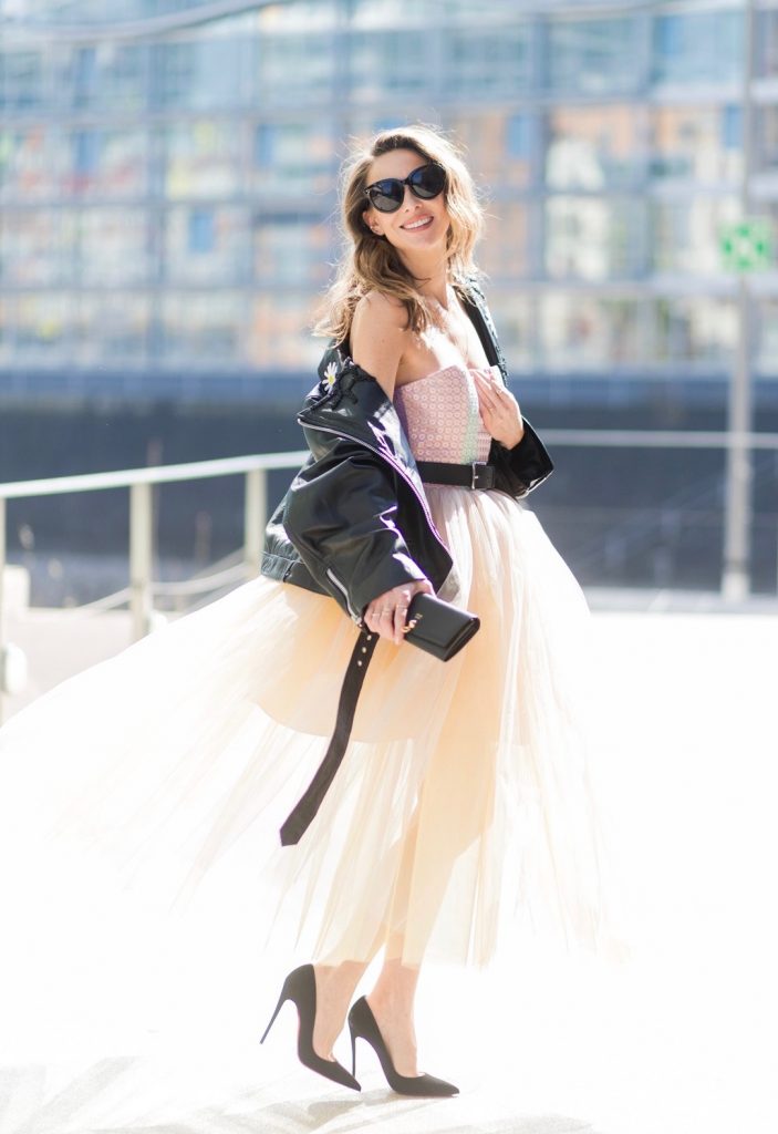 Model and fashion blogger Alexandra Lapp wearing a Carrie Bradshaw style, a multicolored sleeveless brocade tulle dress from Natasha Zinko, a black biker leather jacket with sewed on flowers with pearl applications from Natasha Zinko, black suede So Kate pums from Christian Louboutin, and black sunglasses from Celine on March 30, 2017 in Duesseldorf, Germany.
