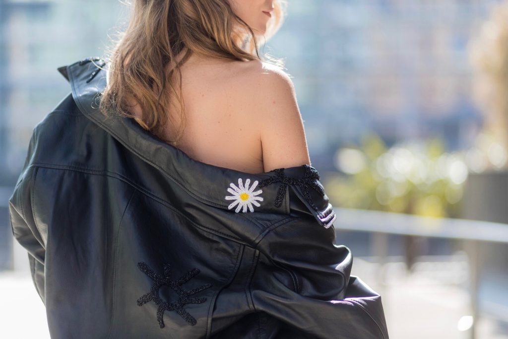 Model and fashion blogger Alexandra Lapp wearing a Carrie Bradshaw style, a multicolored sleeveless brocade tulle dress from Natasha Zinko, a black biker leather jacket with sewed on flowers with pearl applications from Natasha Zinko, black suede So Kate pums from Christian Louboutin, and black sunglasses from Celine on March 30, 2017 in Duesseldorf, Germany.