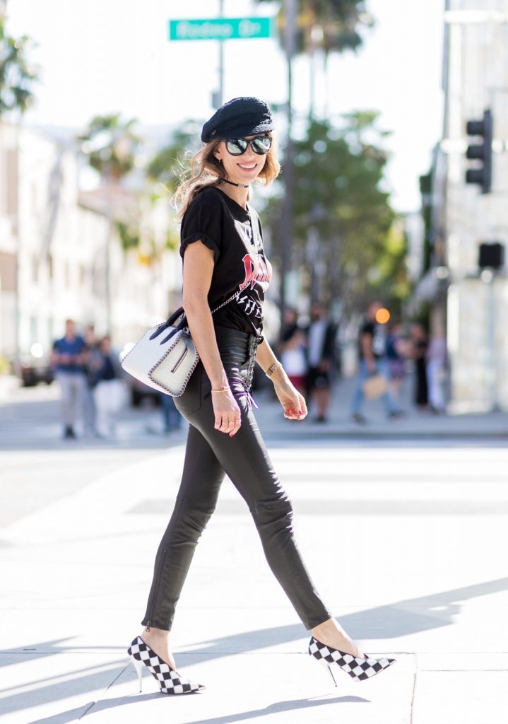Model and fashion blogger Alexandra Lapp wearing V-Neck-Pumps, a LACE FRONT SKINNY LEATHER PANTS by Unravel, Dior High Voltage T-Shirt from Ecntrc, black and white vegan patent Stella McCartney check pointed toe V-neck-pumps with high-cut toe box, Falabella Box mini faux-leather cross-body bag in black and white, Chanel cap, Diormania sunglasses by Dior and Dior choker, IWC Da Vinci Automatic 36 watch in 18-carat red gold with diamonds and jewelry from AYS (Art Youth Society) on April 20, 2017 in Los Angeles, California.