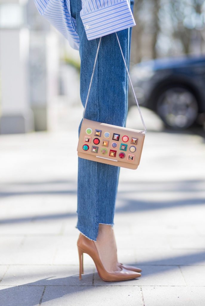 Model and fashion blogger Alexandra Lapp wearing an oversized navy and white striped cotton shirt, cut for an oversized fit with a point collar and dropped shoulders from Vetements, blue jeans from Vetements in cooperation with Levi`s with cut-out raw hems, blue aviator sunglasses from illevesta, Christian Louboutin pumps in cognac, filigree rose gold jewelry from Art Youth Society and a studded embellished crossbody bag from Fendi featuring a foldover top with magnetic closure, an interior zipped compartment, multiple interior card slots and a silver-tone chain shoulder strap on March 30, 2017 in Duesseldorf, Germany.