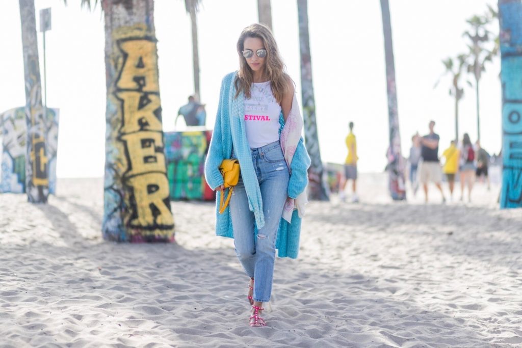 Model and fashion blogger Alexandra Lapp enjoying the beach life, wearing Levis skinny jeans in light blue with a vintage optic, a body from Patrizia Pepe in sensitive white lycra with iridescent and fluorescent laminated Welcome to the Desert Festival print, a long cashmere cardican / coatigan from Heartbreaker in turquoise, a pashmina scarf from Heartbreaker, Valentino Rockstud sandals in pink, a yellow Gucci GG Marmont bag, silver mirrored sunglasses by Le Specs, IWC Da Vinci Automatic 36 watch in 18-carat red gold with diamonds and jewelry from AYS (Art Youth Society) in Venice Beach on April 19, 2017 in Los Angeles, California.