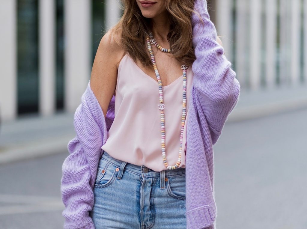 Alexandra Lapp wearing a pastel purple look, a purple cashmere cardigan by Heartbreaker, a rose tank top in silk from Jadicted, a high waist, non-strech denim, five-pocket 501 skinny jeans from Levis, a candy necklace from Chanel supermarket collection in pastel tones, a Chanel perfume bottle bag in plexiglass and a golden chain with white leather, Christian Louboutin pumps Feerica with nude mesh upper embedded with a Swarovski crystal degrade and Karl Lagerfeld cat-eye sunglasses in the shape of cat ears during the Mercedes-Benz Fashion Week Berlin Spring/Summer 2018 on July 7, 2017 in Berlin, Germany.