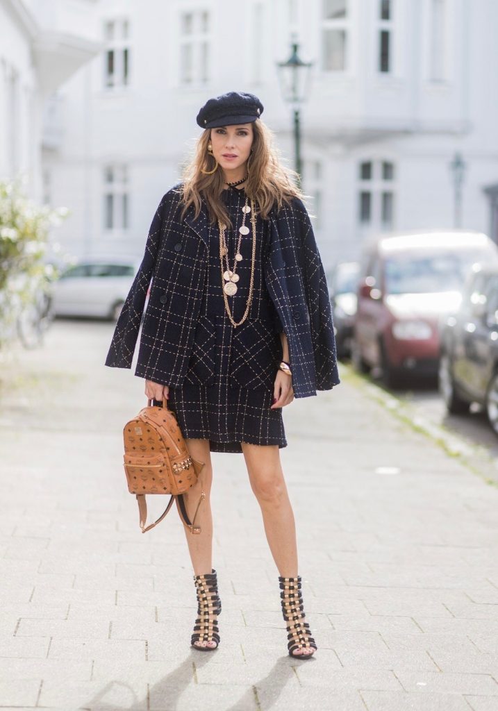 Model and fashion blogger Alexandra Lapp wearing a look inspired by Chanel, a tweed dress and coat from Steffen Schraut, Balmain x HM sandals, Strak backpack by MCM, Chanel tweed cap, golden Chanel chains in form from Chanel coins, Chanel chocker and golden bracelet from Schubart Goldschmiede and golden vintage earrings with a peals by Chanel on August 5, 2017 in Duesseldorf, Germany.
