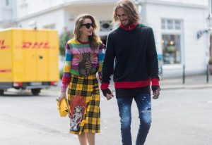 Couple look a like holding hands in front of DHL van - Model and Blogger Alexandra Lapp wearing a Gucci total look, a yellow and red pleated tartan skirt embroidered with a spaniel dog and belt buckle closure, colorful striped sweater with lace and merino with embroidered cat applique all Gucci, black Christian Louboutin So Kate pumps, GG Marmont Gucci bag in yellow, Audrey sunglasses from Celine and Model and Blogger Thomas Stuch wearing classic Kenny Twist Jean from Dsquared, black T-Shirt Thom Krom, Gucci track suit top, Stallion Cowboy Boots on August 4, 2017 in Duesseldorf, Germany.