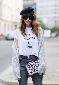 Alexandra Lapp wearing a T-Shirt from H&M, printed with The Revolution Is Female, a high waist, non-strech denim, five-pocket 501 skinny jeans from Levis in grey, Cashmere cardigan in grey, Roger Vivier pumps in a sharp cut and sheeny satin fabric in black and white stripes with crystal flower-embellished buckle at the front and sling-back shape and the 2.55 classic Chanel bag in white leather with black pearls during the Mercedes-Benz Fashion Week Berlin Spring/Summer 2018 on July 7, 2017 in Berlin, Germany.