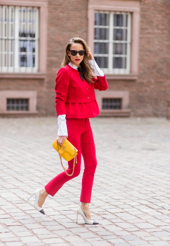 Model and fashion blogger Alexandra Lapp wearing a slim fit, red suit from Steffen Schraut, blazer with peplum and red pants, white blouse with a black ribbon bow from Steffen Schraut, white pumps with black toecap from Saint Laurent, Chanel sunglasses with pearls and yellow GG Marmont bag from Gucci on August 5, 2017 in Duesseldorf, Germany.