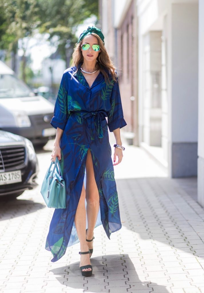 Model and fashion blogger Alexandra Lapp wearing a blue Kimono maxi dress with green leaf print from Borgo de Nor, green metallic Aviator sunglasses by Ray-Ban, plateau heels from Prada, Milla MCM bag in turquoise, a green bandana turban, neck ripe and bracelet in grey gold by Schubart Goldschmiede, three rings in grey gold with a green Tourmaline by Schubart on August 4, 2017 in Duesseldorf, Germany.