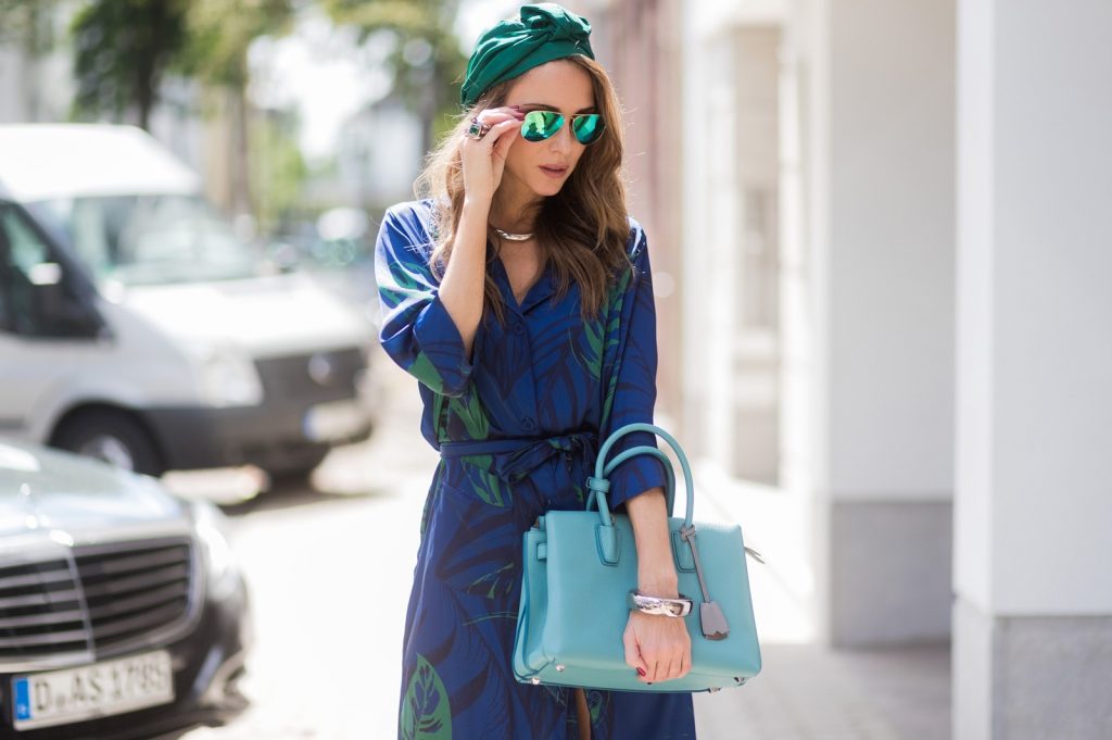 Model and fashion blogger Alexandra Lapp wearing a blue Kimono maxi dress with green leaf print from Borgo de Nor, green metallic Aviator sunglasses by Ray-Ban, plateau heels from Prada, Milla MCM bag in turquoise, a green bandana turban, neck ripe and bracelet in grey gold by Schubart Goldschmiede, three rings in grey gold with a green Tourmaline by Schubart on August 4, 2017 in Duesseldorf, Germany.