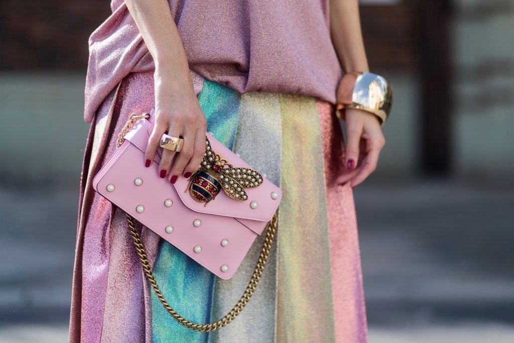 Model and fashion blogger Alexandra Lapp wearing metallic chic, pleated lame skirt in shimmering pastel, pink metallic v-neck knit by Alberta Ferretti, Christian Louboutin Feerica heels with Swarovski crystals and flower accessory, pink Broadway leather bag with pearl studs, Le Specs sunglasses, bracelet and rose gold ring with baguette diamonds by Schubart on August 4, 2017 in Duesseldorf, Germany.