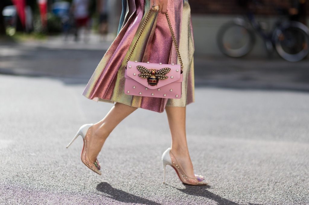 Model and fashion blogger Alexandra Lapp wearing metallic chic, pleated lame skirt in shimmering pastel, pink metallic v-neck knit by Alberta Ferretti, Christian Louboutin Feerica heels with Swarovski crystals and flower accessory, pink Broadway leather bag with pearl studs, Le Specs sunglasses, bracelet and rose gold ring with baguette diamonds by Schubart on August 4, 2017 in Duesseldorf, Germany.