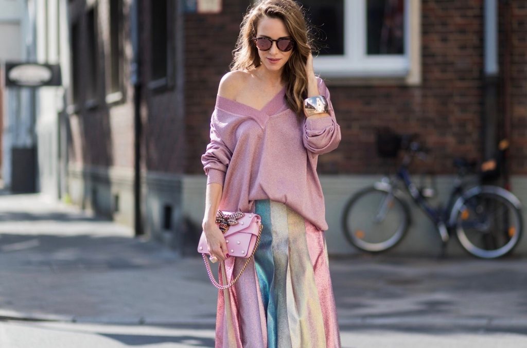 Model and fashion blogger Alexandra Lapp wearing metallic chic, pleated lame skirt in shimmering pastel, pink metallic v-neck knit by Alberta Ferretti, Christian Louboutin Feerica heels with Swarovski crystals and flower accessory, pink Broadway leather bag with pearl studs, Le Specs sunglasses, bracelet and rose gold ring with baguette diamonds by Schubart on August 4, 2017 in Duesseldorf, Germany.