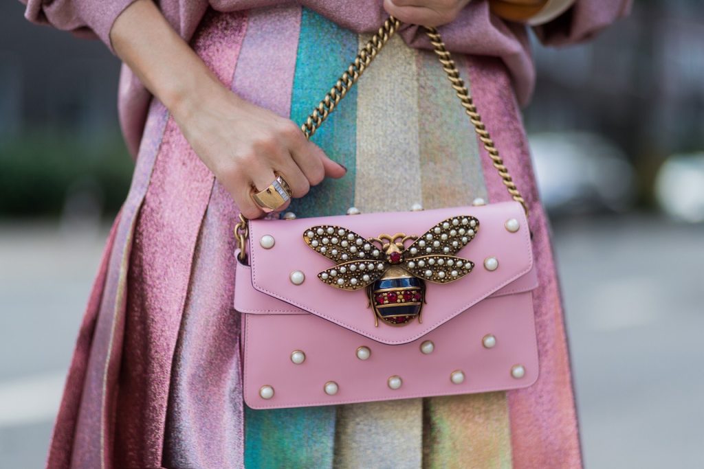 Model and fashion blogger Alexandra Lapp wearing metallic chic, pleated lame skirt in shimmering pastel, pink metallic v-neck knit by Alberta Ferretti, Christian Louboutin Feerica heels with Swarovski crystals and flower accessory, pink Broadway leather bag with pearl studs, Le Specs sunglasses, bracelet and rose gold ring with baguette diamonds by Schubart on August 4, 2017 in Duesseldorf, Germany.