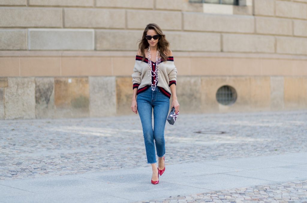 Alexandra Lapp wearing a cashmere cardigan with pearls in beige with a collar in blue and red Levis Wedgie Icon Fit jeans in slim fit and dark blue, a long, pearl necklace from Chanel with the Chanel Logo, brown sunglasses with pearls from Chanel, Fly with Karl clutch from Karl Lagerfeld and cognac So Kate high heels from Christian Louboutin during the Mercedes-Benz Fashion Week Berlin Spring/Summer 2018 on July 7, 2017 in Berlin, Germany.