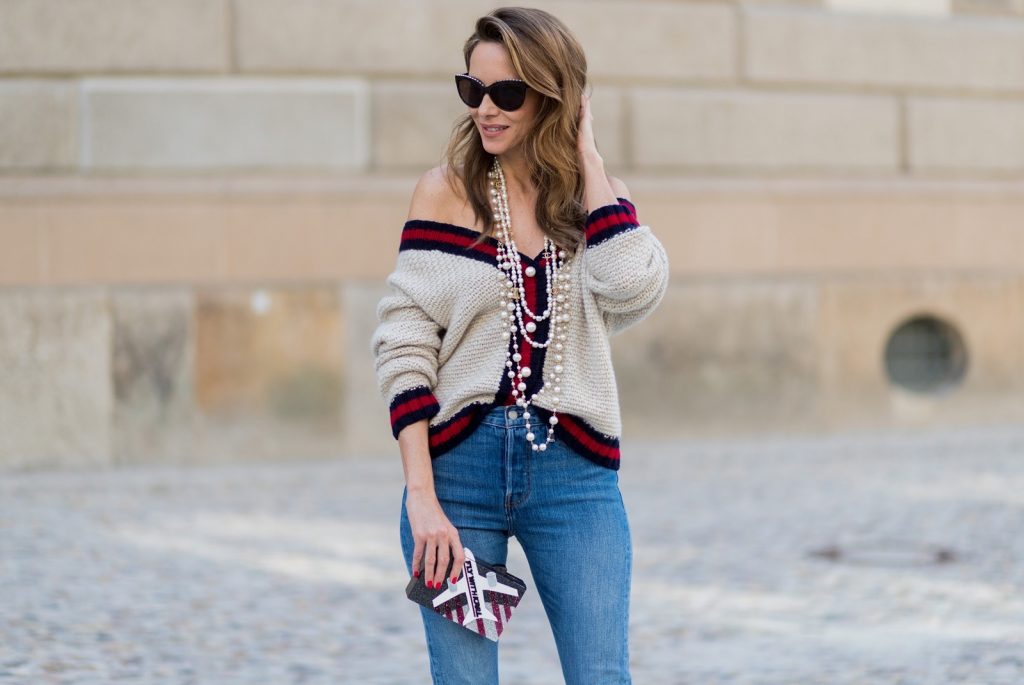 Alexandra Lapp wearing a cashmere cardigan with pearls in beige with a collar in blue and red Levis Wedgie Icon Fit jeans in slim fit and dark blue, a long, pearl necklace from Chanel with the Chanel Logo, brown sunglasses with pearls from Chanel, Fly with Karl clutch from Karl Lagerfeld and cognac So Kate high heels from Christian Louboutin during the Mercedes-Benz Fashion Week Berlin Spring/Summer 2018 on July 7, 2017 in Berlin, Germany.