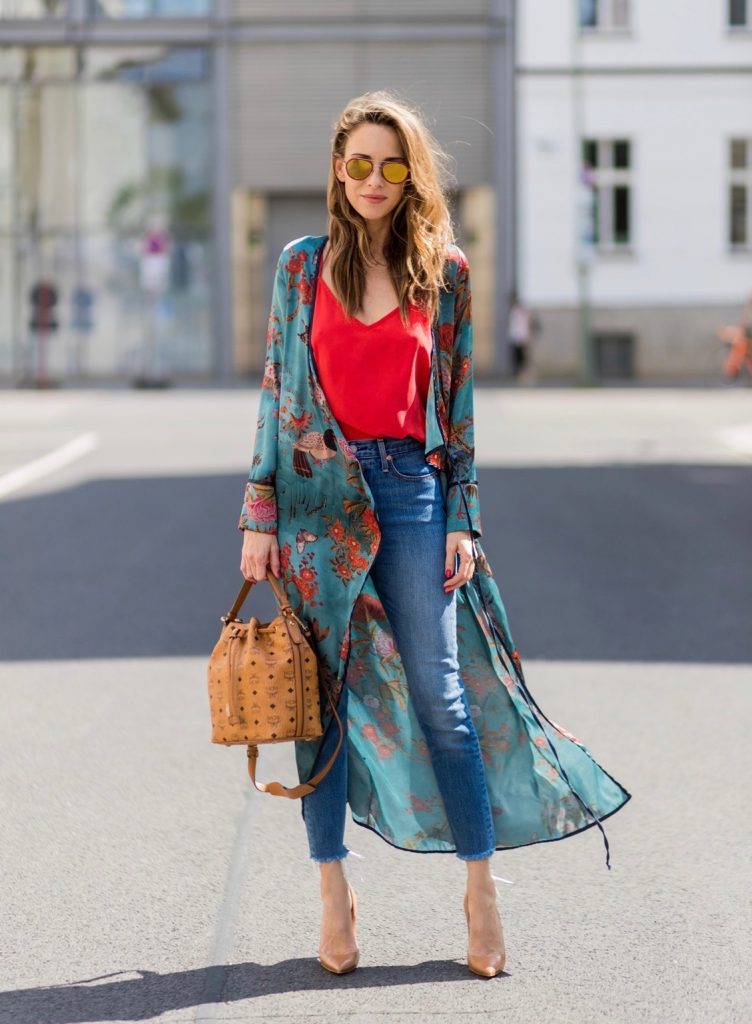 Model and fashion blogger Alexandra Lapp wearing a wrap dress in Kimono style from Zara, silk tank top from Jadicted, petite bucket bag from MCM, Levis Wedgie Icon Fit jeans in slim fit, So Kate pumps in cognac by Christian Louboutin and gold mirrored aviator sunglasses by Thom Browne during the Mercedes-Benz Fashion Week Berlin Spring/Summer 2018 on July 8, 2017 in Berlin, Germany.