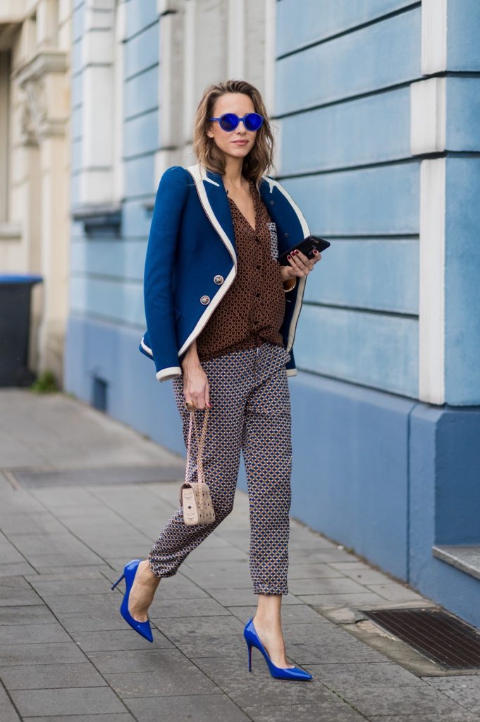 Model and fashion blogger Alexandra Lapp wearing pajama style, silk blouse and pants from Steffen Schraut, blue Balenciaga blazer jacket, blue lacquer pumps from Christian Louboutin, Millie cross body bag in beige from MCM with a golden chain, rose gold bracelet and rose gold ring with baguette diamonds from Schubart Goldschmiede on August 3, 2017 in Duesseldorf, Germany.