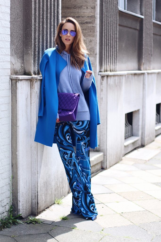  Alexandra Lapp wearing a light blue cashmere hoodie by Heartbreaker, colorful pants in all tones of blue from Emilio Pucci, a blue cashmere coat by Jil Sander, an oversized purple 2.55 tweed bag from Chanel, purple aviator sunglasses from Ray Ban, Gianvito Rossi heels.