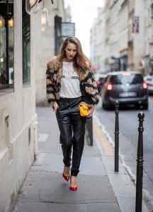 Alexandra Lapp wearing leather trackies in black from Set Fashion, vintage style Gucci logo tee, little fur jacket by Set, yellow GG Marmont matelasse shoulder bag by Gucci, red lacquer heels from Gianvito Rossi and Audrey sunglasses from Celine is seen during Paris Fashion Week Spring/Summer 2018 on September 27, 2017 in Paris, France.