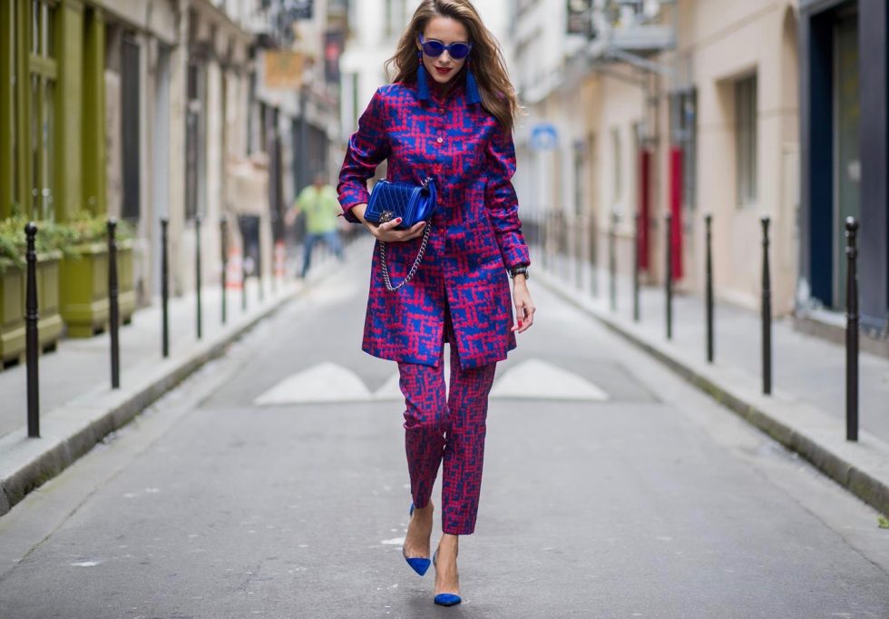 Alexandra Lapp wearing a two-piece suit in red and blue by Riani, a blue lacquer Chanel Boy bag, blue sunglasses by Etnia Barcelona, plexi pumps in blue from Gianvito Rossi and blue tassel earrings from Zara is seen during Paris Fashion Week Spring/Summer 2018 on September 26, 2017 in Paris, France.