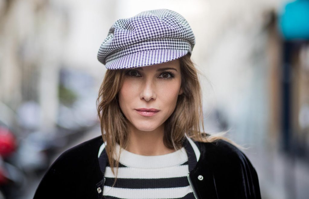 Alexandra Lapp wearing French Chic, an A-line leather rocky biker skirt from SET Fashion, striped knit jumper from Zara, plaid Zara hat, Isabel Marant slouchy boots, detailed with chain-trimmed ties to wrap around the leg, black Boy bag from Chanel and velvet bomber jacked with a Cosmo application is seen during Paris Fashion Week Spring/Summer 2018 on September 29, 2017 in Paris, France.