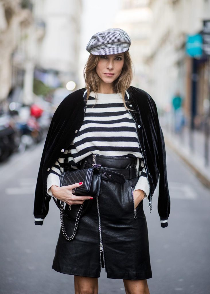 Alexandra Lapp wearing French Chic, an A-line leather rocky biker skirt from SET Fashion, striped knit jumper from Zara, plaid Zara hat, Isabel Marant slouchy boots, detailed with chain-trimmed ties to wrap around the leg, black Boy bag from Chanel and velvet bomber jacked with a Cosmo application is seen during Paris Fashion Week Spring/Summer 2018 on September 29, 2017 in Paris, France.