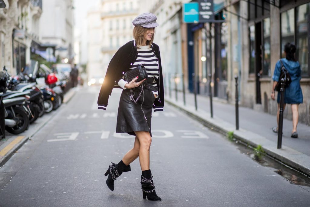 Alexandra Lapp wearing French Chic, an A-line leather rocky biker skirt from SET Fashion, striped knit jumper from Zara, plaid Zara hat, Isabel Marant slouchy boots, detailed with chain-trimmed ties to wrap around the leg, black Boy bag from Chanel and velvet bomber jacked with a Cosmo application is seen during Paris Fashion Week Spring/Summer 2018 on September 29, 2017 in Paris, France.