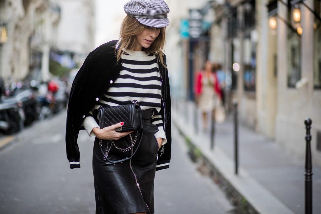 Alexandra Lapp wearing French Chic, an A-line leather rocky biker skirt from SET Fashion, striped knit jumper from Zara, plaid Zara hat, Isabel Marant slouchy boots, detailed with chain-trimmed ties to wrap around the leg, black Boy bag from Chanel and velvet bomber jacked with a Cosmo application is seen during Paris Fashion Week Spring/Summer 2018 on September 29, 2017 in Paris, France.