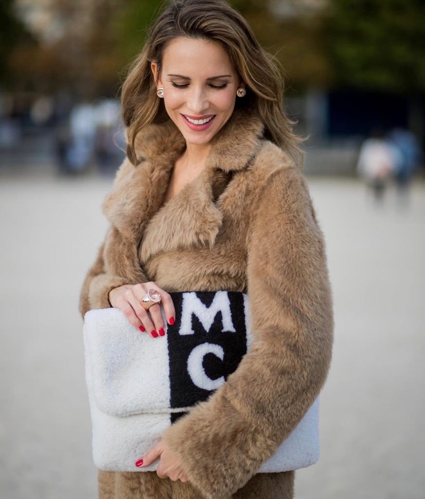Alexandra Lapp wearing Morganite jewelry, rings and earrings by Schubart an oversized MCM Stark Pouch in Shearling Stripe, a lambskin coat in light brown by Yves Salomon, black and white big waist-belt from Balmain and striped Christian Louboutin 'So Kate' heels is seen during Paris Fashion Week Spring/Summer 2018 on September 28, 2017 in Paris, France.