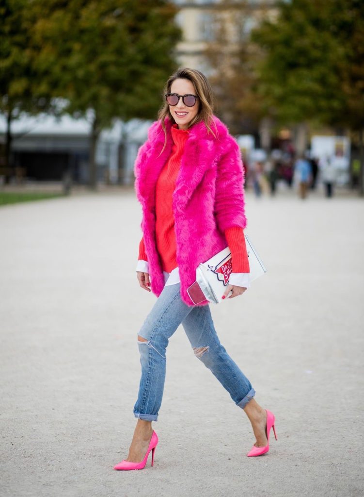 Alexandra Lapp wearing a fake fur jacket in pink from Jakke with a Faux Real statement on the back, red cashmere jumper by Heartbreaker with golden buttons, a long white blouse by Celine, Levis ReDone denim, Christian Louboutin heels in neon pink, sunglasses by Le Specs and a clutch by Yazburkey with a Dazzlin Smile application is seen during Paris Fashion Week Spring/Summer 2018 on September 27, 2017 in Paris, France.