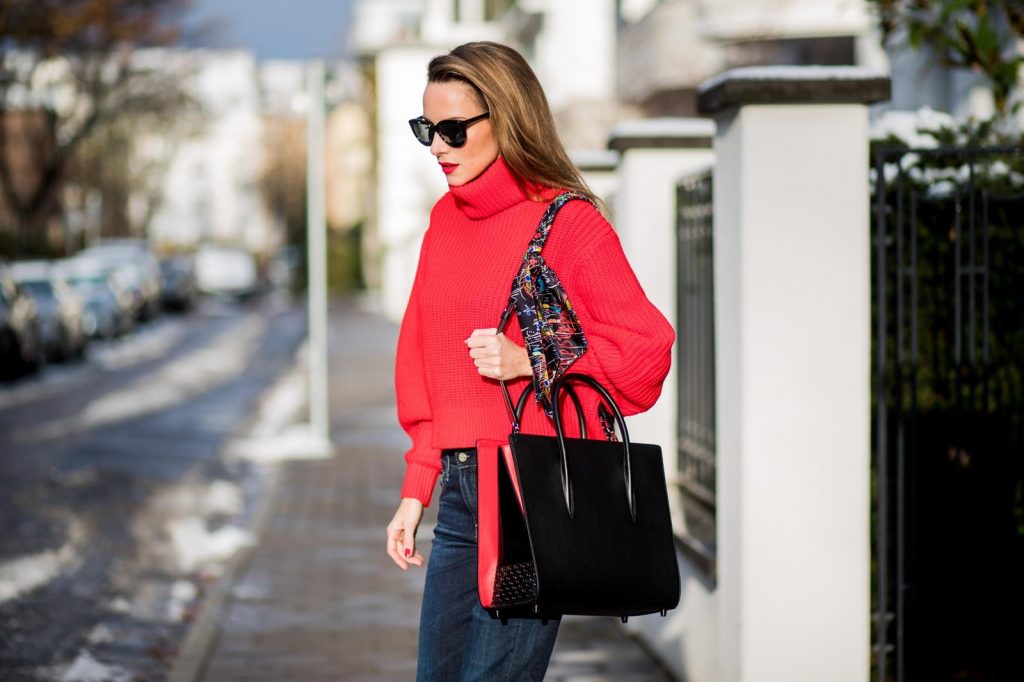 Alexandra Lapp wearing a cropped red turtleneck from H&M, Adriano Goldschmied Boyfriend denim from AG Jeans, Diormania sunglasses by Dior, Opyum 110 ankle boots in patent from Dior, Paloma medium handbag from Christian Louboutin, IWC watch on December 11, 2017 in Duesseldorf, Germany.