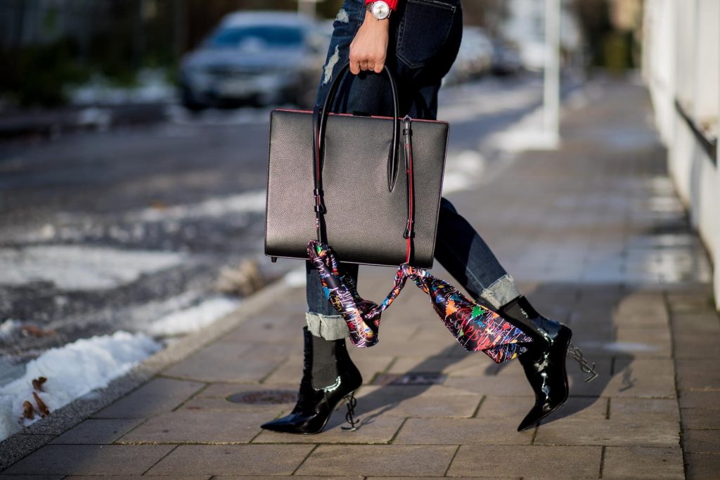 Alexandra Lapp wearing a cropped red turtleneck from H&M, Adriano Goldschmied Boyfriend denim from AG Jeans, Diormania sunglasses by Dior, Opyum 110 ankle boots in patent from Dior, Paloma medium handbag from Christian Louboutin, IWC watch on December 11, 2017 in Duesseldorf, Germany.