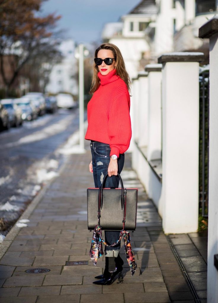 Alexandra Lapp wearing a cropped red turtleneck from H&M, Adriano Goldschmied Boyfriend denim from AG Jeans, Diormania sunglasses by Dior, Opyum 110 ankle boots in patent from Dior, Paloma medium handbag from Christian Louboutin, IWC watch on December 11, 2017 in Duesseldorf, Germany.