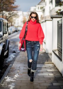 Alexandra Lapp wearing a cropped red turtleneck from H&M, Adriano Goldschmied Boyfriend denim from AG Jeans, Diormania sunglasses by Dior, Opyum 110 ankle boots in patent from Dior, Paloma medium handbag from Christian Louboutin, IWC watch on December 11, 2017 in Duesseldorf, Germany.