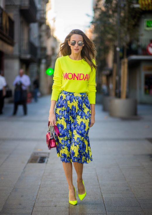 Alexandra Lapp wearing the yellow Alberta Ferretti Monday jumper, pleated skirt with flower prints by Balenciaga, a dark red quilted small boy bag by Chanel, neon yellow pumps by Christian Louboutin and silver Ray Ban sunglasses on November 29, 2017 in Barcelona, Spain.