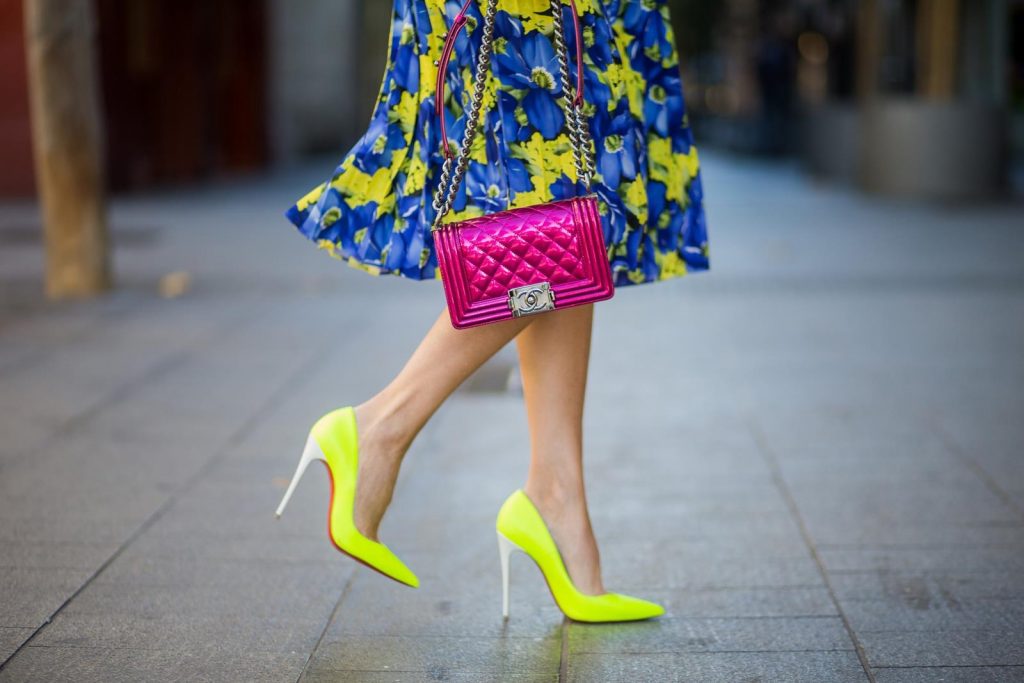 Alexandra Lapp wearing the yellow Alberta Ferretti Monday jumper, pleated skirt with flower prints by Balenciaga, a dark red quilted small boy bag by Chanel, neon yellow pumps by Christian Louboutin and silver Ray Ban sunglasses on November 29, 2017 in Barcelona, Spain.