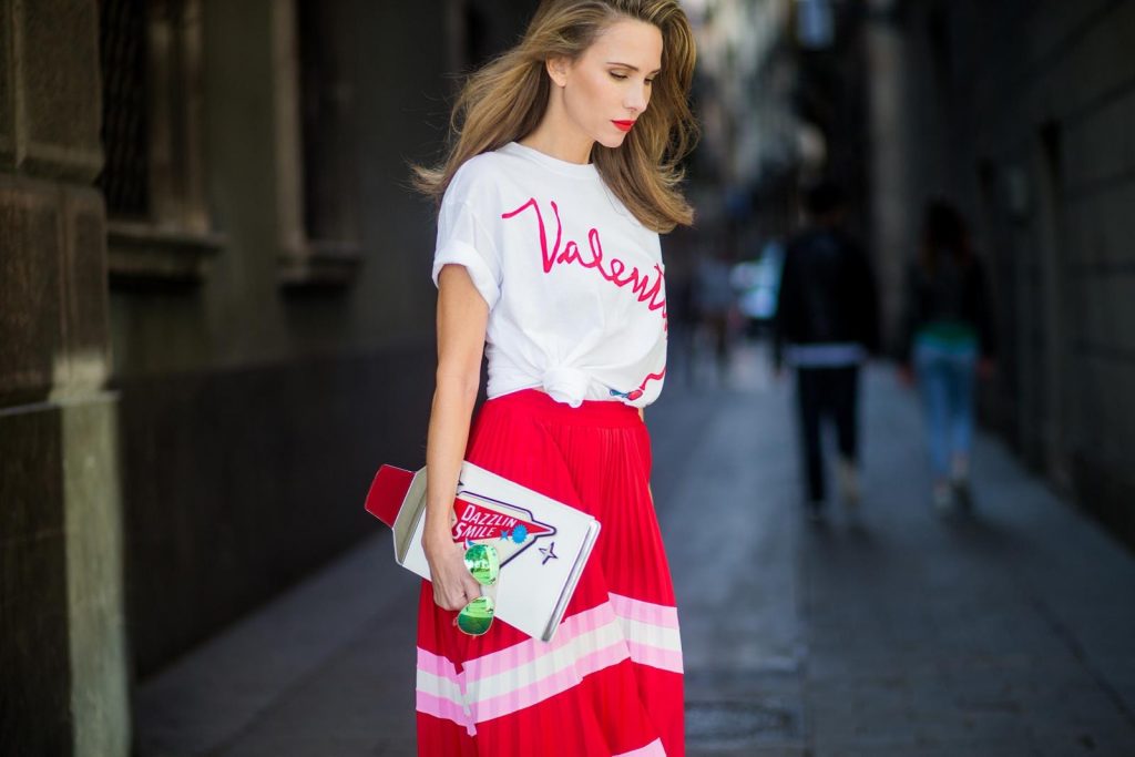 Let us swing - Alexandra Lapp wearing a pleated skirt from Valentino, white t-shirt from Valentino with label print written over the chest with red lipstick, high heel sandals from Sophia Webstar with butterflies on the back, handbag in shape of toothpaste from Yazbukey on November 27, 2017 in Barcelona, Spain.