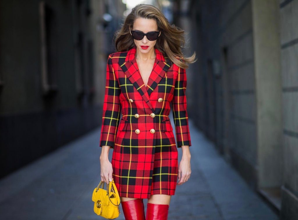 Alexandra Lapp wearing a look all about red, a red checked plaid wool blazer-dress with golden buttons by Balmain, ribbed knit Fendi thigh boots in red Rockoko leather, a yellow Marmont matelasse shoulder bag by Gucci and black Audrey sunglasses by Celine on November 27, 2017 in Barcelona, Spain.
