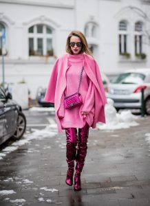 On Wednesdays we wear pink, Alexandra Lapp wearing overknee boots in metallic pink from Christian Louboutin, metallic pink Boy bag from Chanel, pink sunglasses from Le Specs, light pink knit dress from H&M and light pink cashmere coat from Prada on December 10, 2017 in Duesseldorf, Germany.
