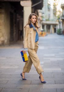BARCELONA, SPAIN - NOVEMBER 27: Alexandra Lapp wearing Safari look, wide cut khaki pants from Steffen Schraut, khaki jacket with blue collar and blue and white strips on the bottom of the sleeve from Steffen Schraut, denim shirt by Steffen Schraut, So Kate Pumps from Christian Louboutin in denim, Chanel 2.55 bag in red, blue and yellow with golden logo buckle on November 27, 2017 in Barcelona, Spain.