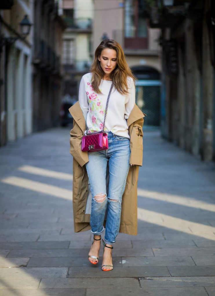 BARCELONA, SPAIN - NOVEMBER 29: Trench coat Hype in Barcelona, Alexandra Lapp wearing and beige oversized egg shaped Audrey trench coat from G-Lab, off-white round neck cashmere pullover with flower applications in pastel tones, vintage Leviss from Re Done, Sophia Webster Chiara sandal heels with a butterfly at the back and Chanel Boy bag in patent pink on November 29, 2017 in Barcelona, Spain.