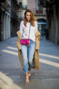 BARCELONA, SPAIN - NOVEMBER 29: Trench coat Hype in Barcelona, Alexandra Lapp wearing and beige oversized egg shaped Audrey trench coat from G-Lab, off-white round neck cashmere pullover with flower applications in pastel tones, vintage Leviss from Re Done, Sophia Webster Chiara sandal heels with a butterfly at the back and Chanel Boy bag in patent pink on November 29, 2017 in Barcelona, Spain.