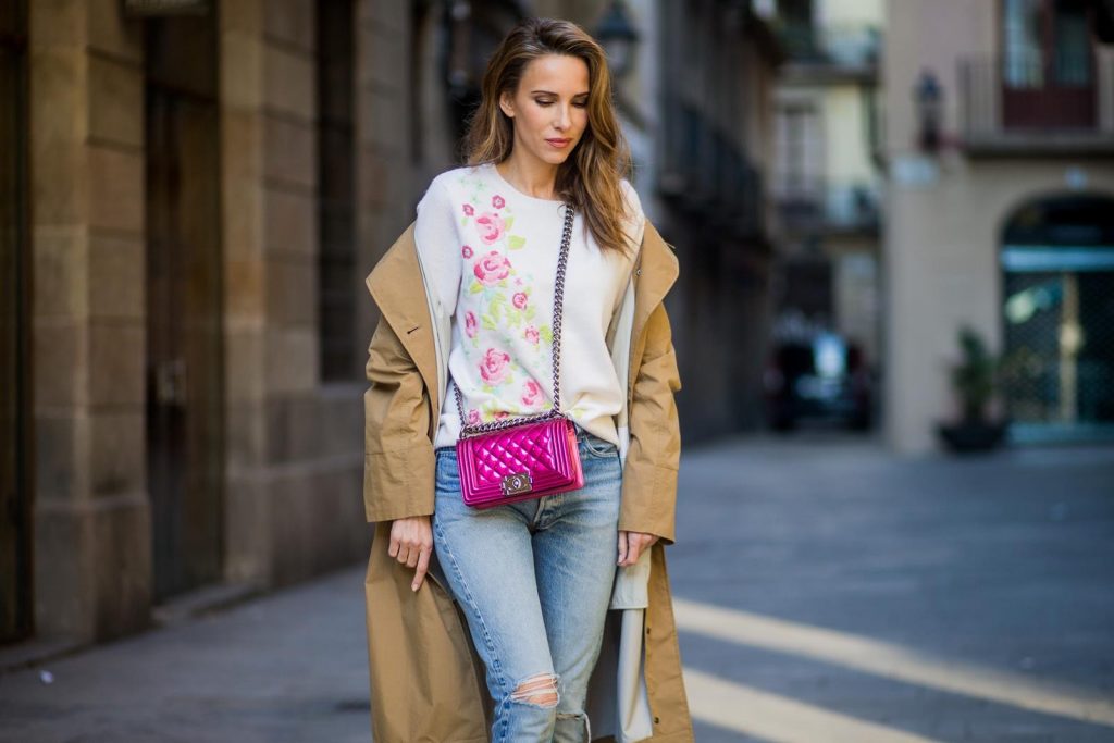 BARCELONA, SPAIN - NOVEMBER 29: Trench coat Hype in Barcelona, Alexandra Lapp wearing and beige oversized egg shaped Audrey trench coat from G-Lab, off-white round neck cashmere pullover with flower applications in pastel tones, vintage Leviss from Re Done, Sophia Webster Chiara sandal heels with a butterfly at the back and Chanel Boy bag in patent pink on November 29, 2017 in Barcelona, Spain.