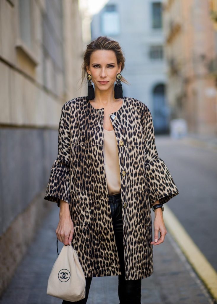 BARCELONA, SPAIN - NOVEMBER 29: Take a walk on the wild side, Alexandra Lapp wearing an animal printed jacket with voluminous bell sleeves by Steffen Schraut, a straight cut silk top in light gold, black skinny leather pants from Current Elliott, sand-black Chanel Mules in suede, black Tassel Earrings by Farina for NA-KD and tote bag in beige from Chanel with Chanel logo on November 29, 2017 in Barcelona, Spain.